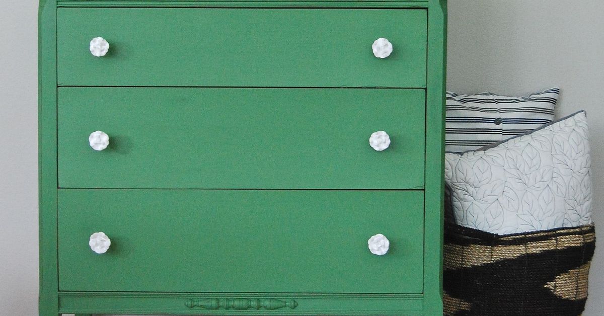 A Mossy Green Dresser With White Rose Knobs